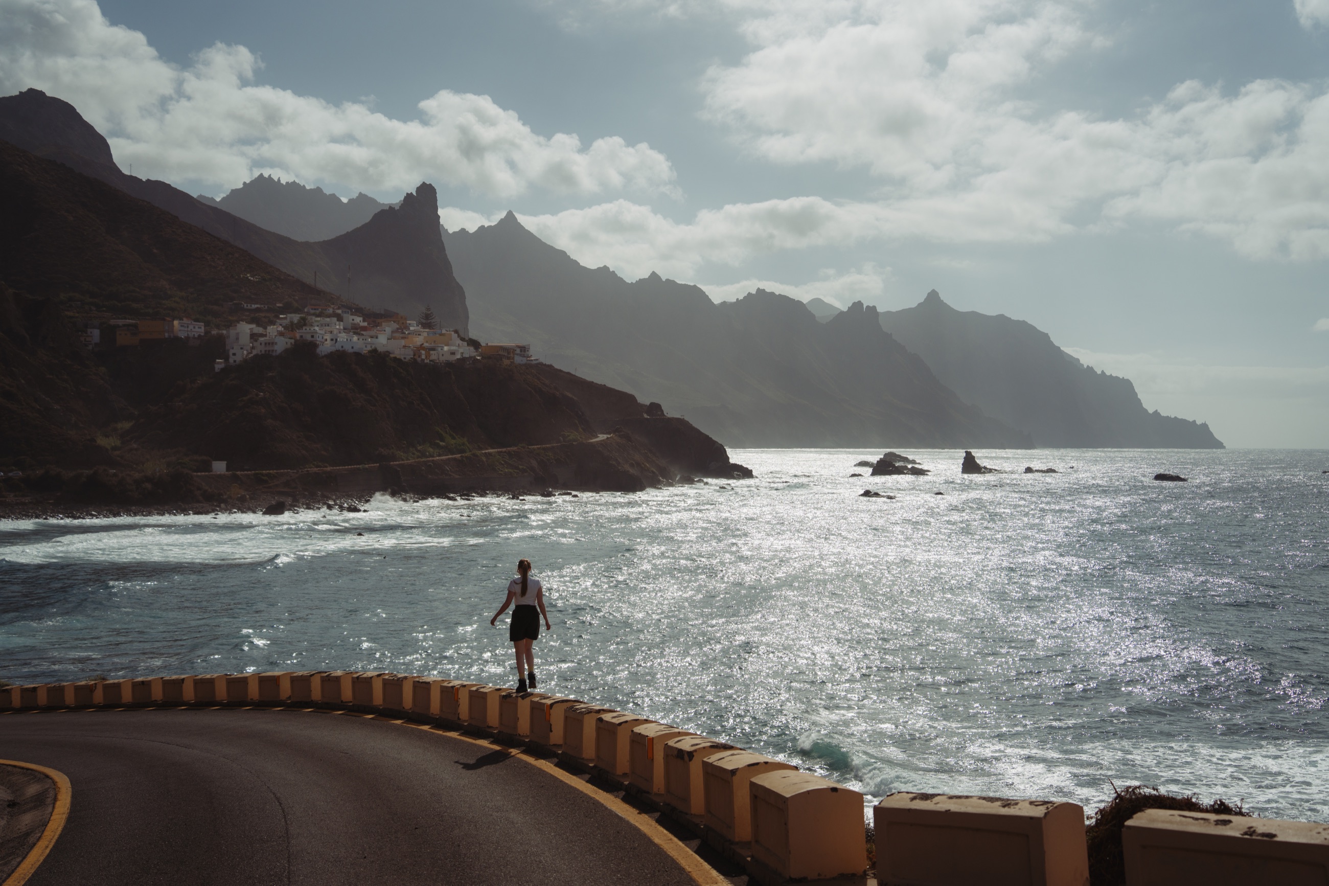Person beside a winding road overlooking Tenerife’s Atlantic coastline