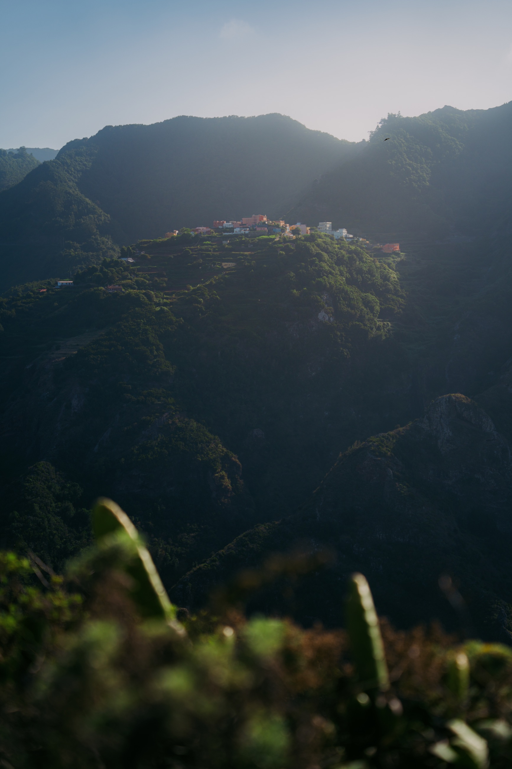 Sunlit village nestled among the dark mountains of Tenerife